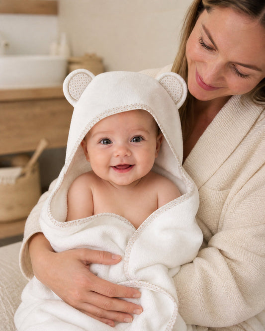Mother holding her smiling baby in the Starry Bear hooded towel