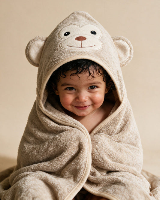Toddler smiling in The Monkey hooded towel