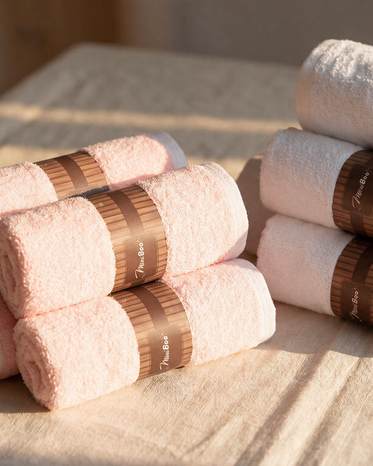 MiniBoo pink baby washcloths rolled with kraft bands on linen