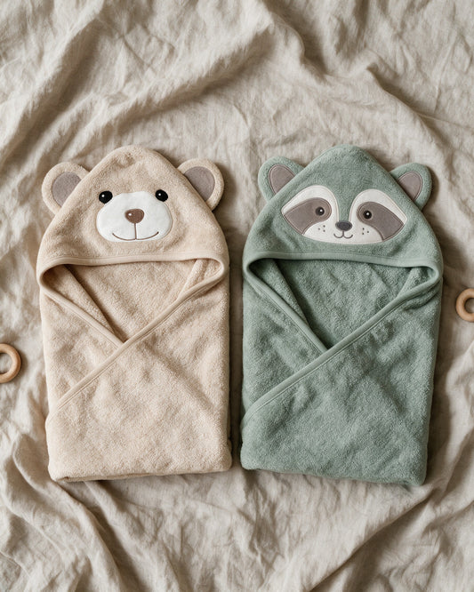 Cream Bear and Raccoon hooded towels on linen