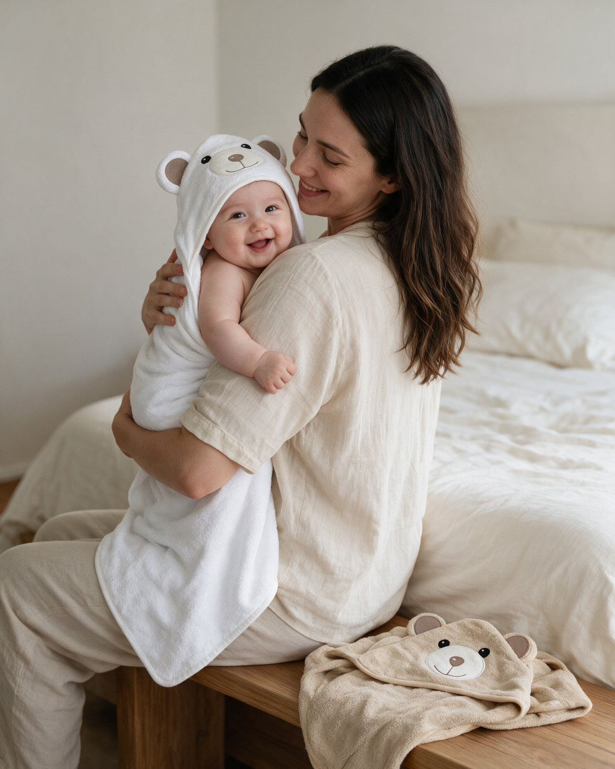 Mother cuddling her baby wrapped in the white Little Bear hooded towel