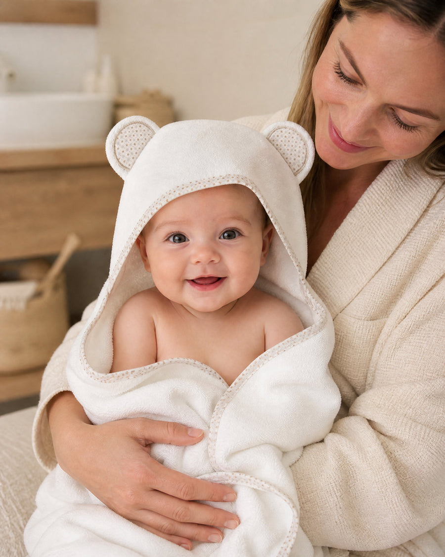 Mother holding her smiling baby in the Starry Bear hooded towel