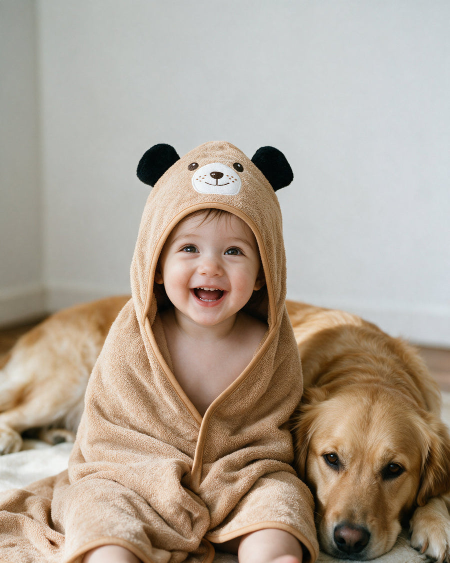Toddler in The Dog hooded towel next to a golden retriever