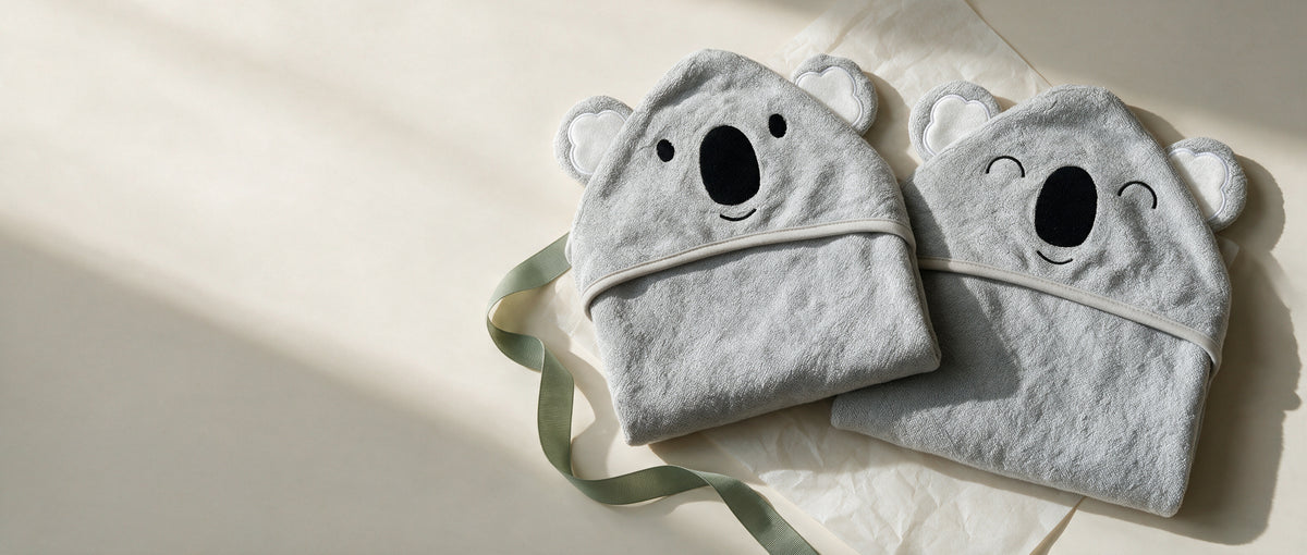 The Koala and Sleepy Koala hooded towels side by side with a sage ribbon
