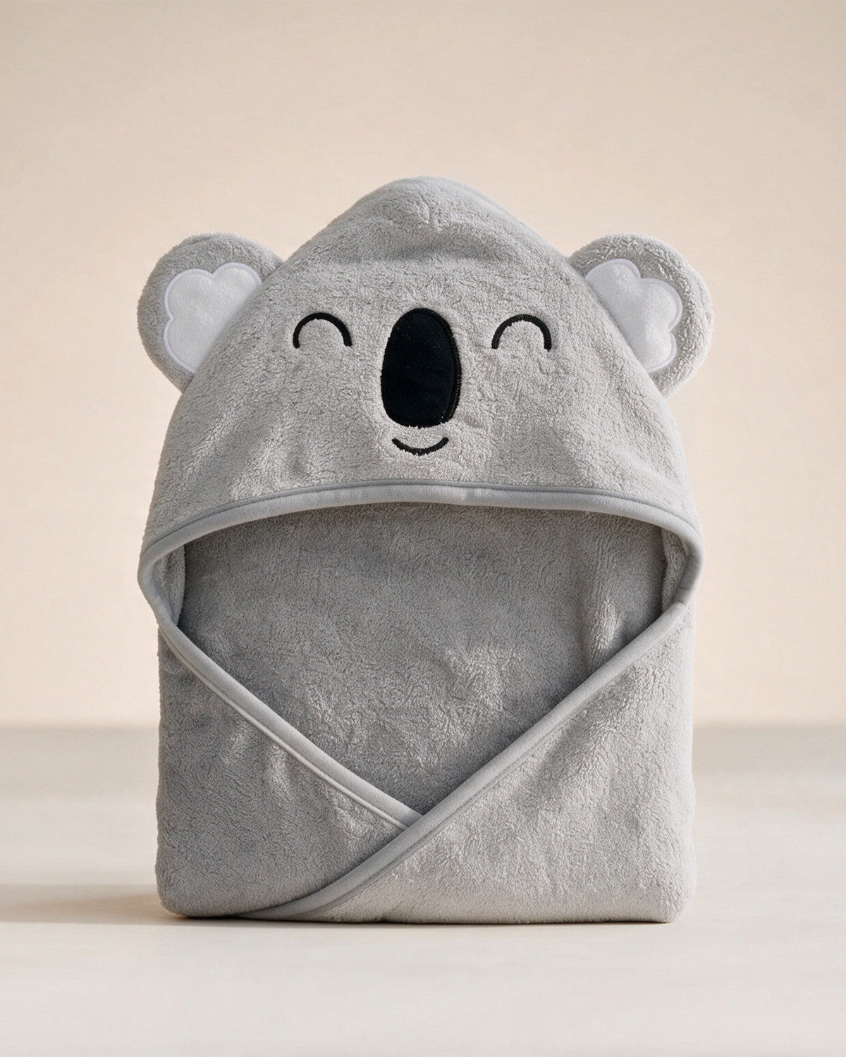 Sleepy Koala hooded baby towel in grey with closed embroidered eyes, on a cream background