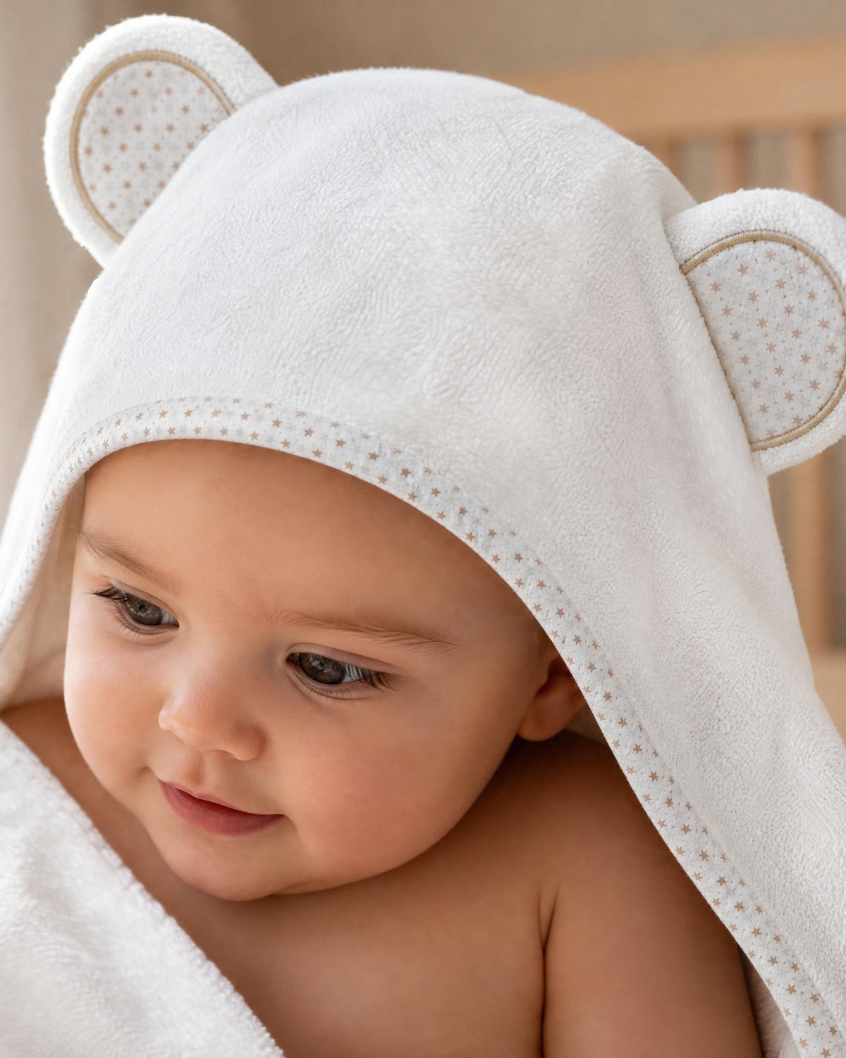 Close-up of a baby in the Starry Bear hood with its star-print trim