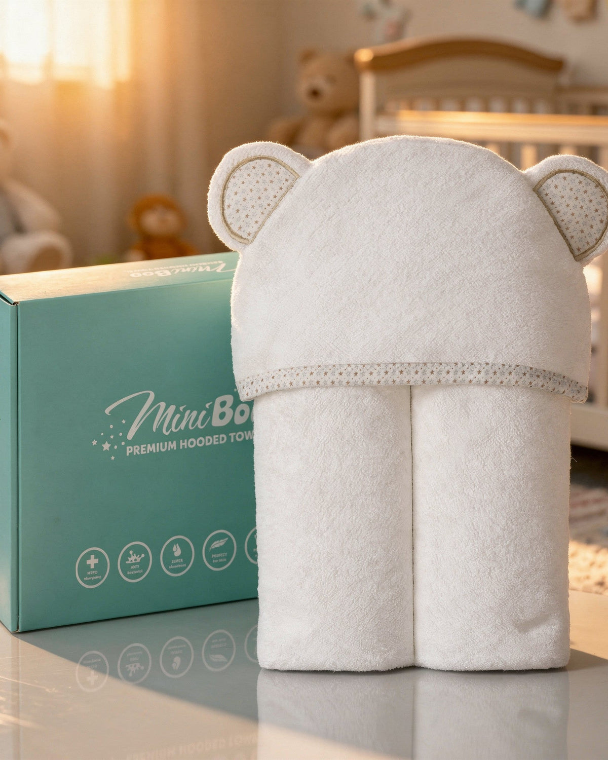 The Starry Bear hooded towel standing next to its MiniBoo box
