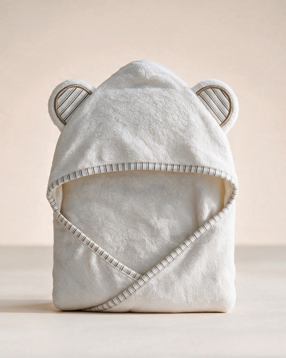 Striped Cub hooded baby towel in white with striped trim and ears, on a cream background