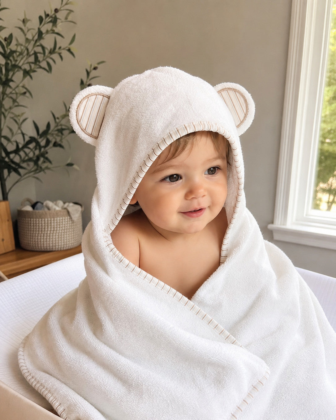 Baby wrapped in the Striped Cub towel by the window