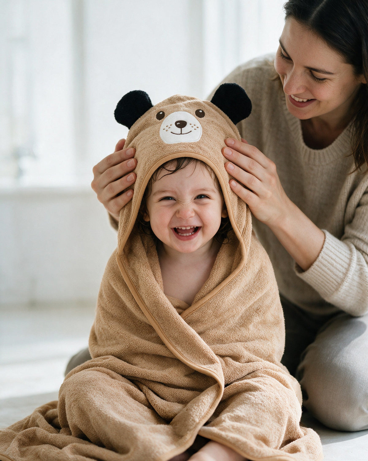 Mother adjusting the dog hood on her laughing toddler