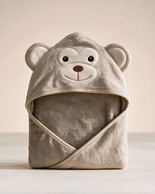 The Monkey hooded baby towel in cream beige, on a cream background