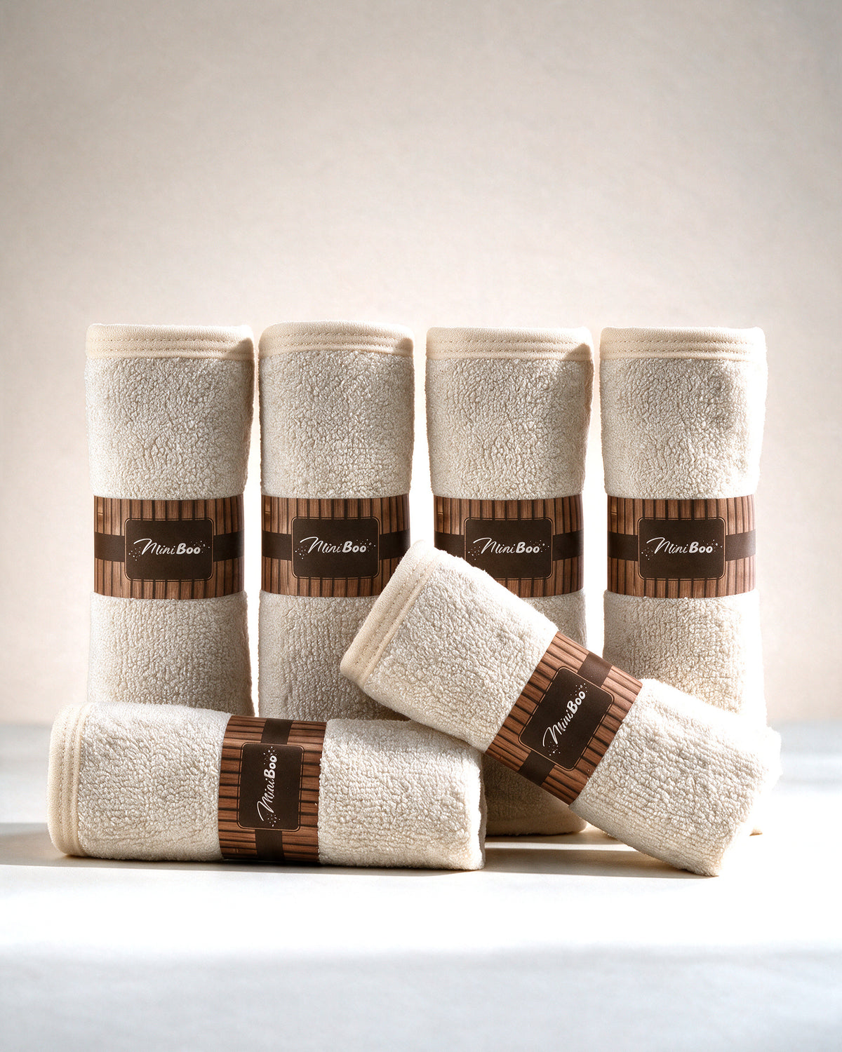 MiniBoo cream baby washcloths, set of 6 rolled with kraft bands, on a cream background