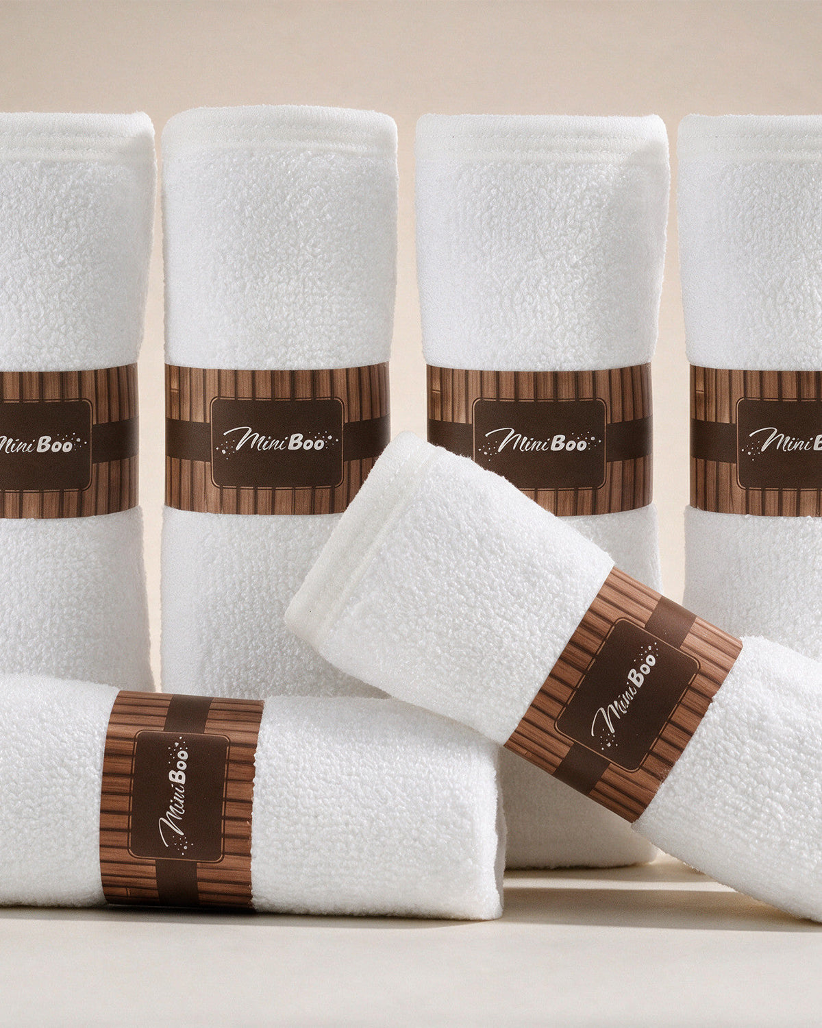 MiniBoo white baby washcloths, set of 6 rolled with kraft bands, on a cream background